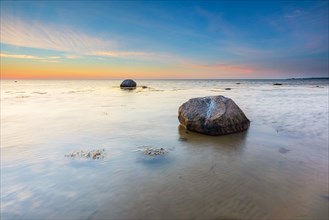 Large boulders on the beach of the Baltic Sea at sunset