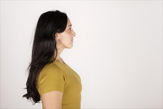 Portrait of a young latin woman in profile on white background