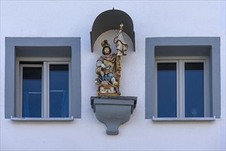 Figure of St Florian under a canopy on a house