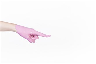 Person s hand with pink paint pointing finger white background