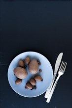 Plate with chocolate eggs near cutlery