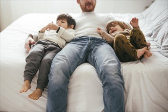 Playful father bed with sons
