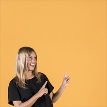 Portrait happy woman pointing upward direction looking up