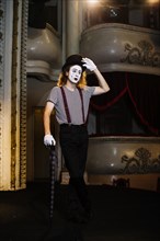 Portrait mime male artist posing with umbrella stage