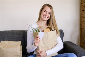 Portrait smiley woman holding groceries bag