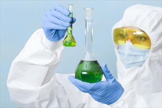 Scientist holding green chemicals