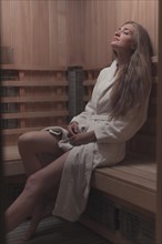 Sexy young woman relaxing wooden sauna