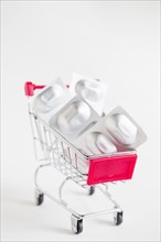 Sliver blister pills miniature shopping cart white background