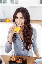 Smiling woman drinking juice breakfast