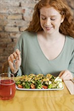 Woman eating vegetarian food medium shot