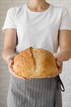 Woman holding fresh round bread