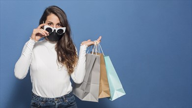 Woman wearing mask holding shopping bags