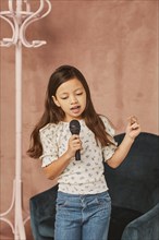 Young girl learning how sing home