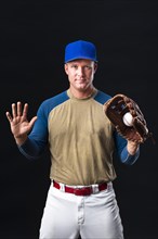 Baseball player with cap posing with glove