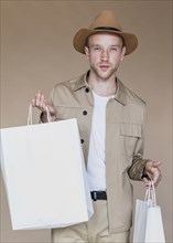 Blond man with shopping bags looking camera