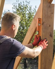 Carpenter man taking measures wood plank