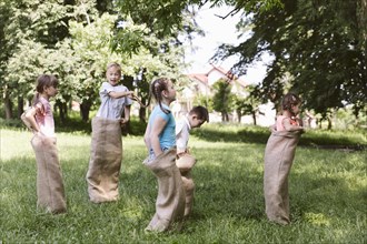 Children running burlap bags