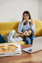 Chilling girls watching movie eating pizza