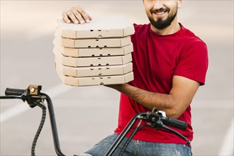 Close up delivery man holding pizza boxes