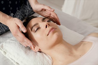 Close up therapist massaging patient s ears