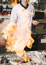 Cook holding burning pan hand