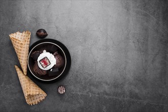 Copy space bowl with ice cream scoops beside ice cream cones