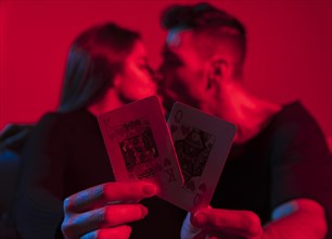 Couple holding king queen hearts playing cards hands