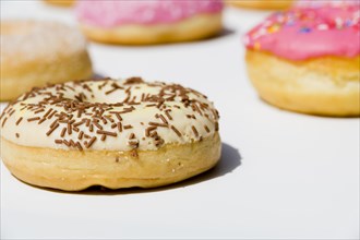 Delicious donuts with sprinkles white backdrop