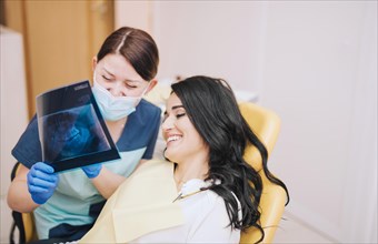 Female dentist showing teeth x ray patient