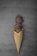 Flat lay cone with three scoops chocolate ice cream