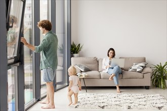 Full shot couple with baby living room
