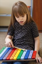 Girl with down syndrome playing with xylophone