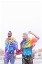 Homosexual couple colorful powder having fun parade