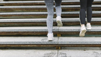 Low section two female runner jogging staircases