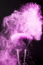 Makeup brush with neon pink powder splash