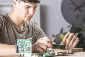 Male it technician inserting ram memory computer motherboard