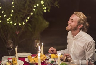 Man laughing while sitting festive table
