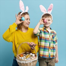 Mother son covering eyes with painted egg
