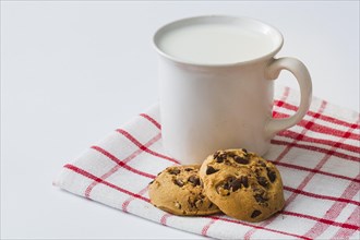 Mug milk with cookies napkin white background