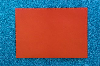 Red cardboard paper blue glitter background