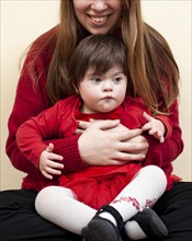 Smiley woman holding child with down syndrome