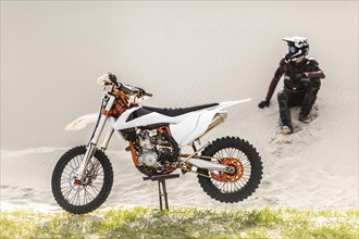 Stylish rider with motorbike desert