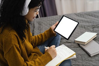 Teenage girl using tablet online school