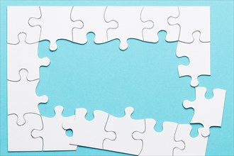 Top view incomplete puzzle frame blue backdrop