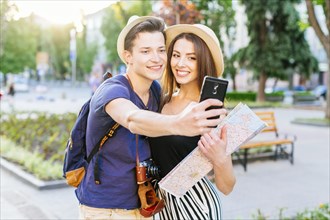 Tourist couple taking selfie park