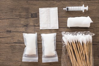 White medical cotton gauze bandage syringe pack cotton swab wooden table