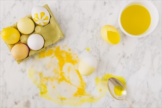 Yellow easter eggs container near spoon dye liquid