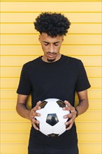Young black man with soccer ball closed eyes