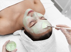 Beautician applying face mask female client 3
