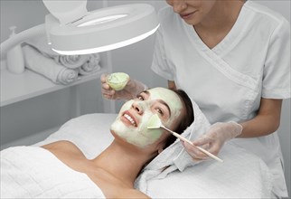 Beautician applying face mask female client 6
